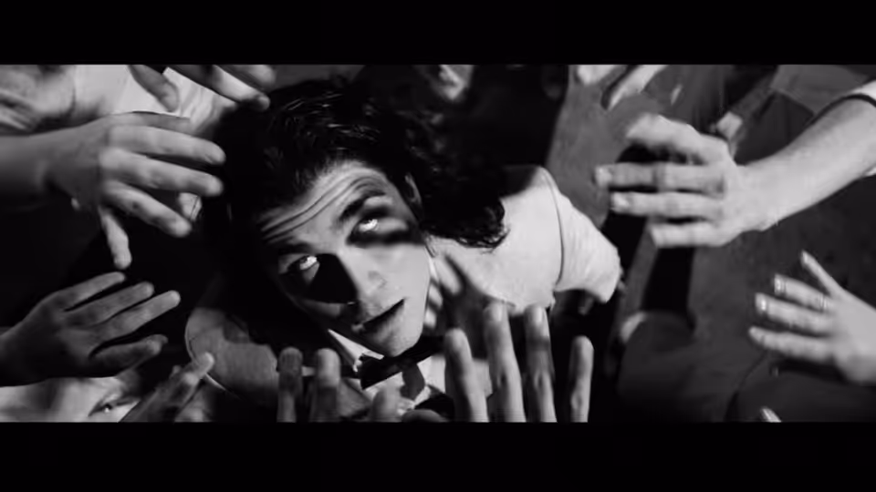 The Pianist (Jack McLaughlin) on the floor with hands reaching toward him