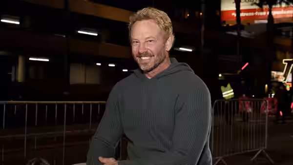 Host Ian Ziering smiles beside a railing at a nighttime event