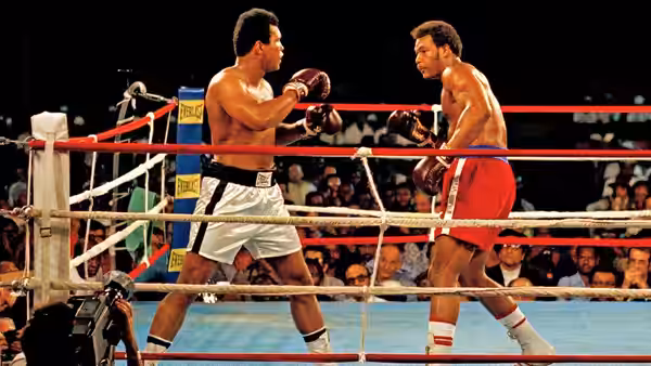 Muhammad Ali and George Foreman facing each other in the boxing ring