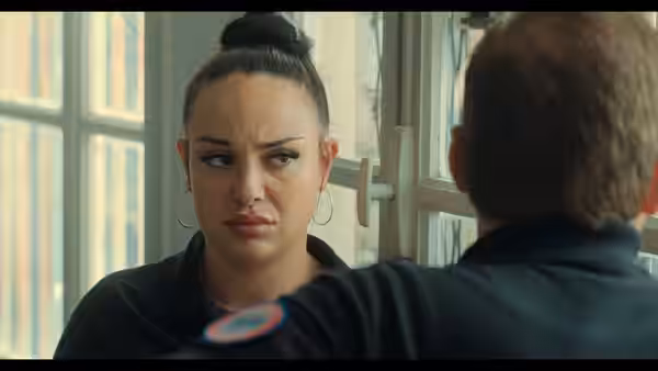 Woman with hair in a bun facing a man intently