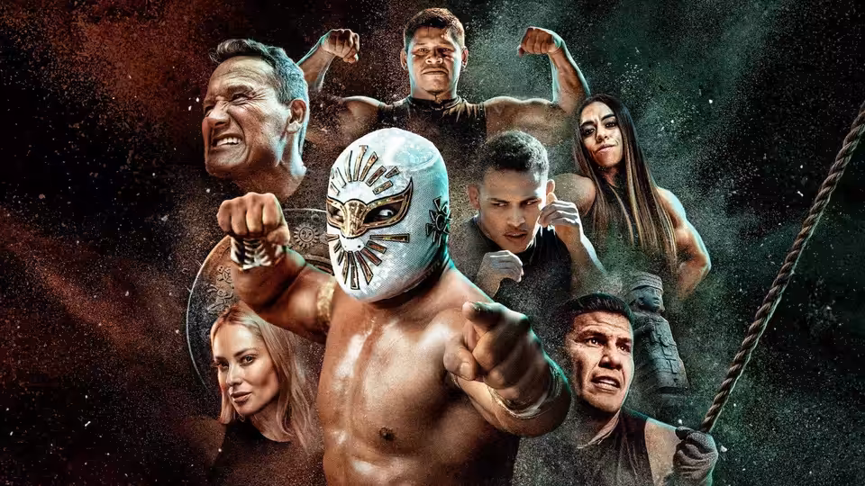 A masked wrestler points forward as competitors flex and pose against a dark backdrop