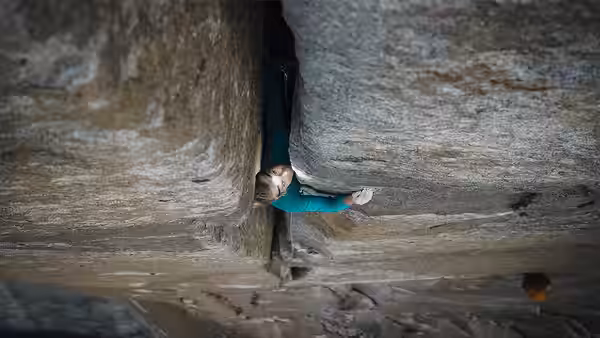 A climber wedged inside a narrow rock crack