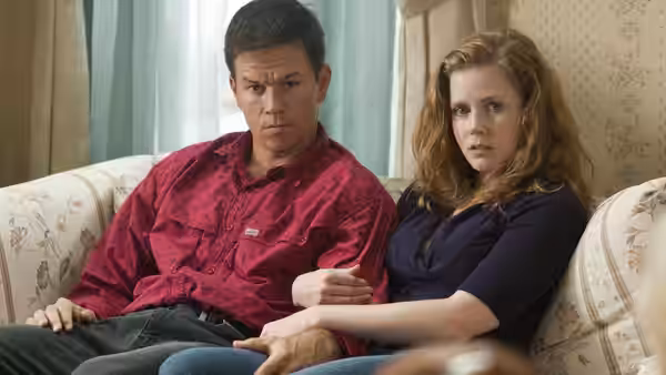 Micky Ward (Mark Wahlberg) and Charlene Fleming (Amy Adams) sit closely on a couch
