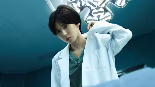 A woman in a white coat adjusts her sleeve in an operating room