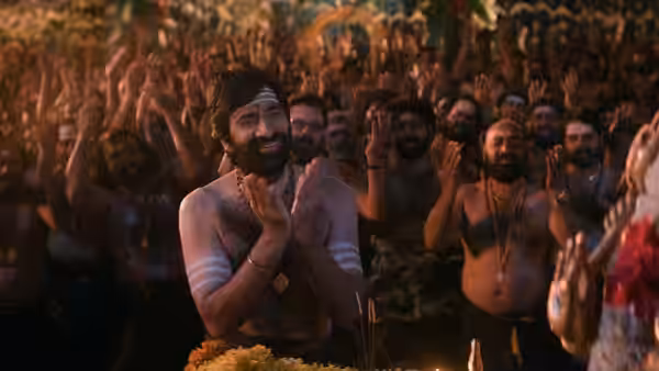 A bearded pilgrim joins a crowd of devotees praying beside a ceremonial fire