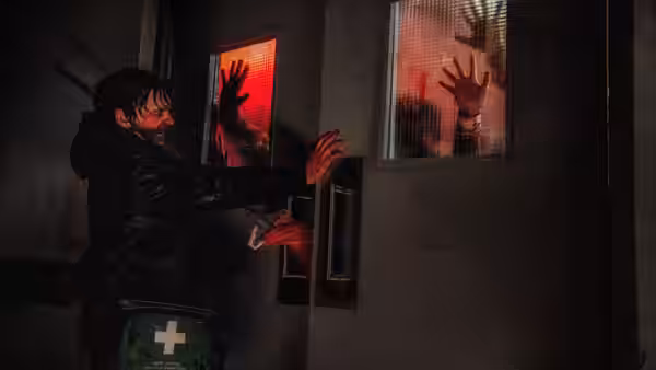 Man reaches toward doors as bloody hands press against windows from behind