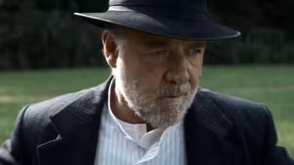 Warden Clancy (Russell Crowe) standing outdoors in a hat and suit