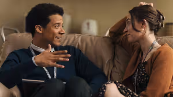 Maria (Saoirse Ronan) and Sam (Jacob Anderson) talking on a sofa