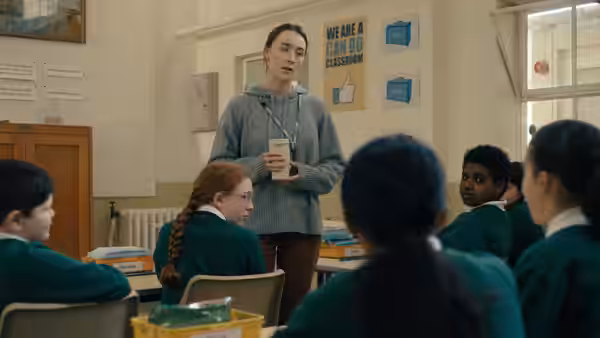 Maria (Saoirse Ronan) addressing students in a school classroom