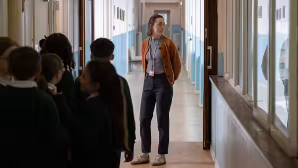 Maria (Saoirse Ronan) walking through a school corridor