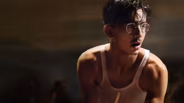 Marty Mauser (Timothée Chalamet) in a white tank top holding a paddle