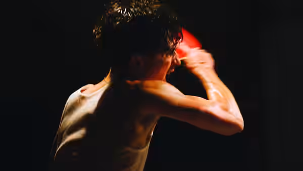 Marty Mauser (Timothée Chalamet) swinging a red paddle from behind