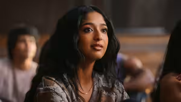 young woman with long dark hair looking aside in a lecture hall