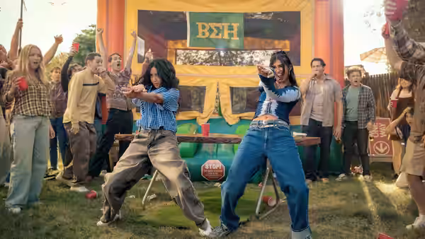 two women dancing on a table before a cheering festival crowd