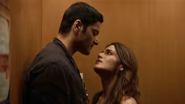 Man and woman stand close face to face in a wooden elevator