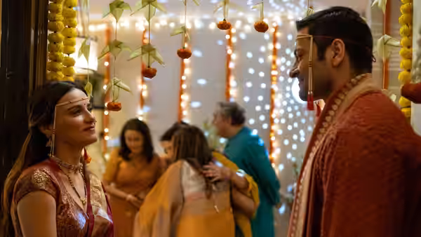A woman and a man facing each other at a festively decorated indoor event