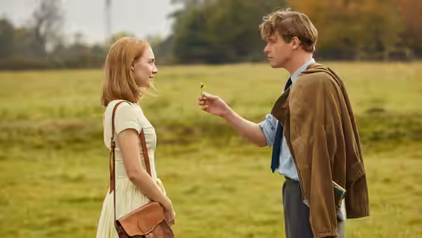 Edward Mayhew (Billy Howle) offering a flower to Florence Ponting (Saoirse Ronan) in a field