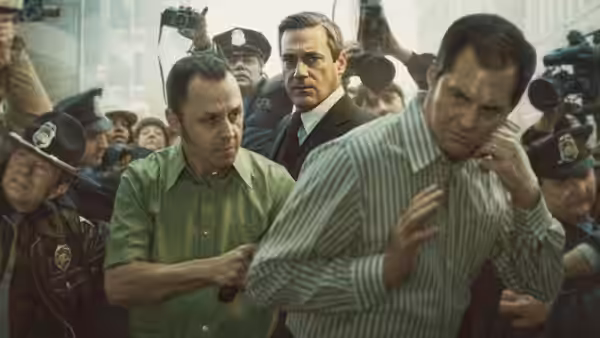 Tony Kiritsis (Giovanni Ribisi) and Fred Heckman (Jon Hamm) escorted by police amid reporters