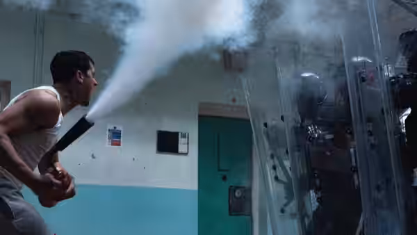 A man spraying a fire extinguisher toward riot police with shields