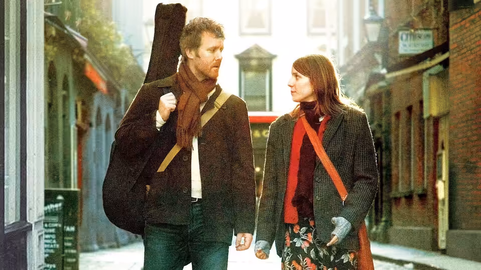 Guy (Glen Hansard) and Girl (Markéta Irglová) walking hand in hand along a city street
