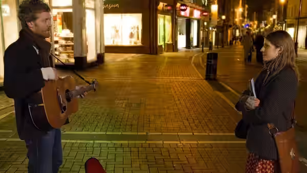 Guy (Glen Hansard) playing guitar to Girl (Markéta Irglová) on an empty street at night