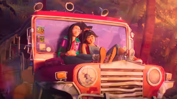Two young women ride together inside a brightly colored vehicle