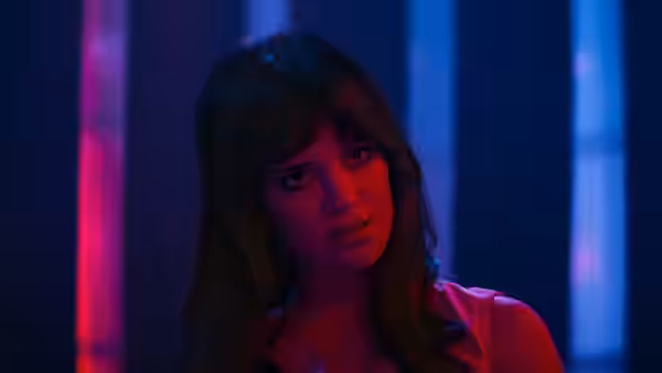 Woman with brown hair looking sideways in blue and red light