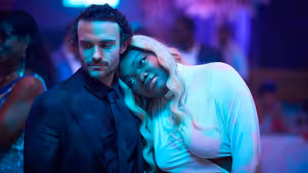 A woman rests her head on a man's shoulder at a nightclub