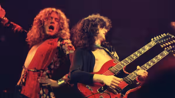 Robert Plant singing as Jimmy Page plays double-neck guitar onstage