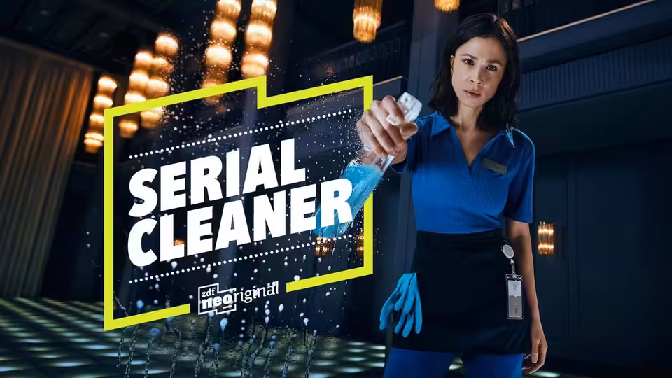 Teri Marquard (Aylin Tezel) in a blue uniform wipes a glass panel with a cloth