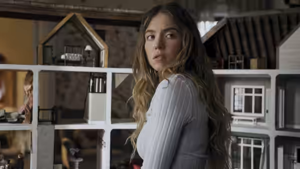 Millie Calloway (Sydney Sweeney) stands before a wall of dollhouses