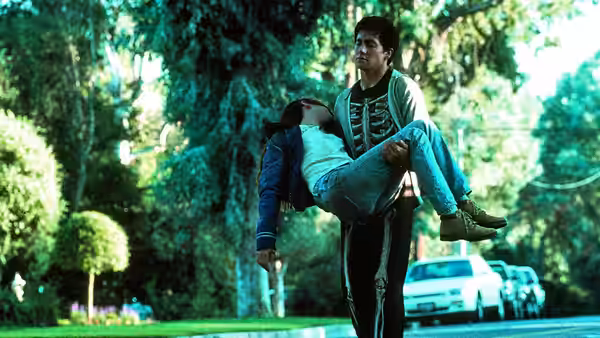Donnie Darko (Jake Gyllenhaal) carries a young woman in his arms outdoors