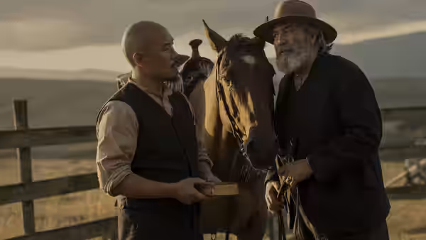 Lee (Hoon Lee) holds a box beside a horse as Samuel Hamilton (Ciarán Hinds) grips its reins