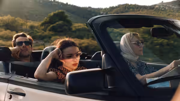 Anne (Chloë Sevigny) driving a convertible with two passengers inside