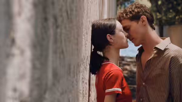 Cécile (Lily McInerny) and Cyril (Aliocha Schneider) about to kiss against a wall