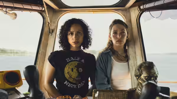 Two women stand together inside the cabin of a riverboat
