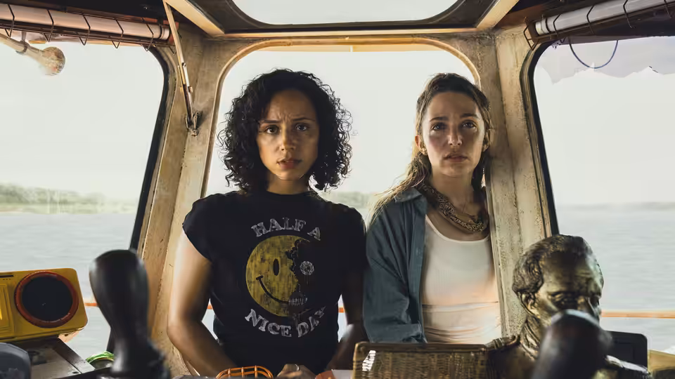 Two women stand together inside the cabin of a riverboat