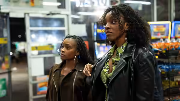 Two women stand inside a brightly lit convenience store