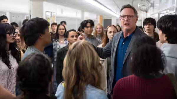 Principal Grayle (Matthew Lillard) addressing students in a school hallway