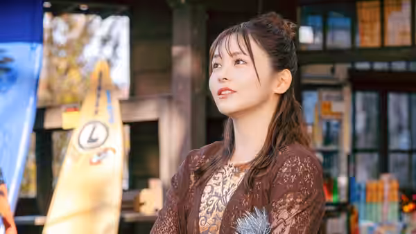 A woman stands outside a storefront, looking upward