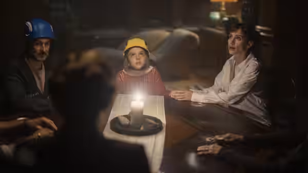 Ursula (Jessica Chastain), Daddo and Bela sit around a table with a candle