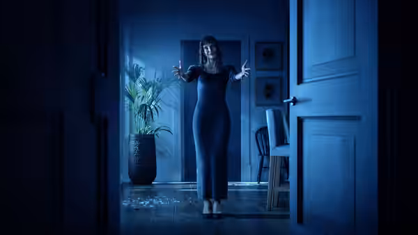 Ursula Martin (Jessica Chastain) stands with outstretched arms in a blue-lit doorway