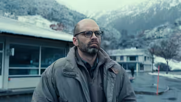 Mihai Gheorghiu (Sebastian Stan) standing in a snowy mountain town