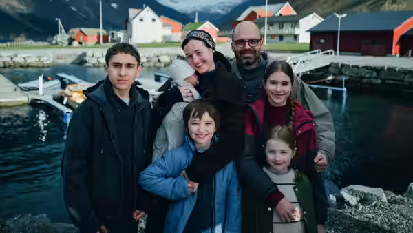 Mihai Gheorghiu (Sebastian Stan) posing with family by a harbor