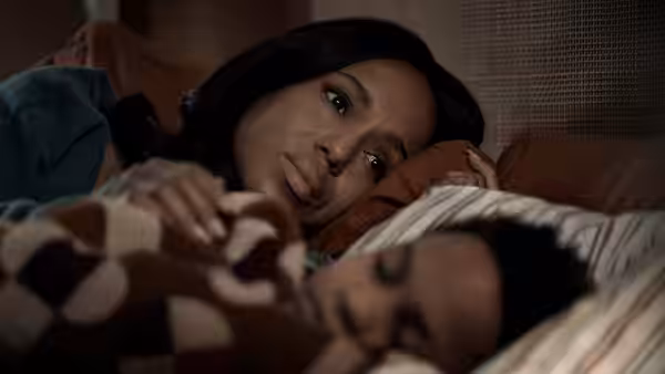 Abigail (Kerry Washington) lying in bed beside a young boy
