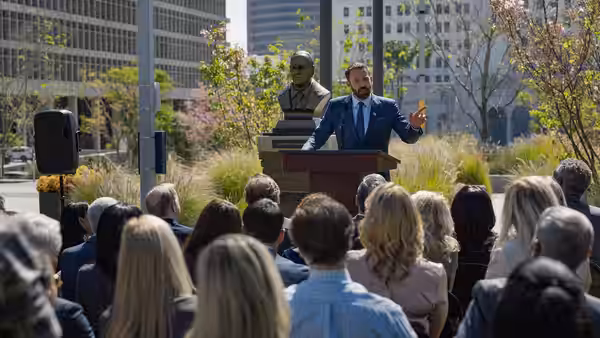 Mark Kimball (Ben Affleck) addresses a seated crowd from an outdoor podium