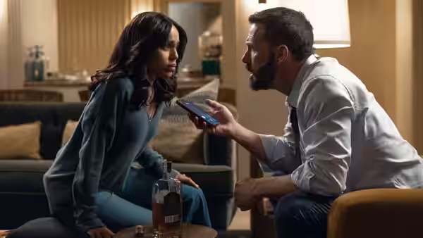 Mark Kimball (Ben Affleck) shows Abigail (Kerry Washington) his phone in a living room