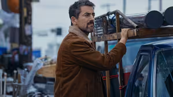 A man loads metal equipment onto a pickup truck