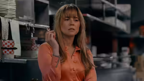 Pamela Voorhees (Linda Cardellini) stands in a kitchen, holding a cigarette
