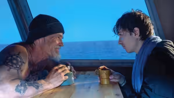 Mitt Gardiner (Josh Brolin) and Jay Gardiner (Austin Abrams) sit across a table aboard a boat